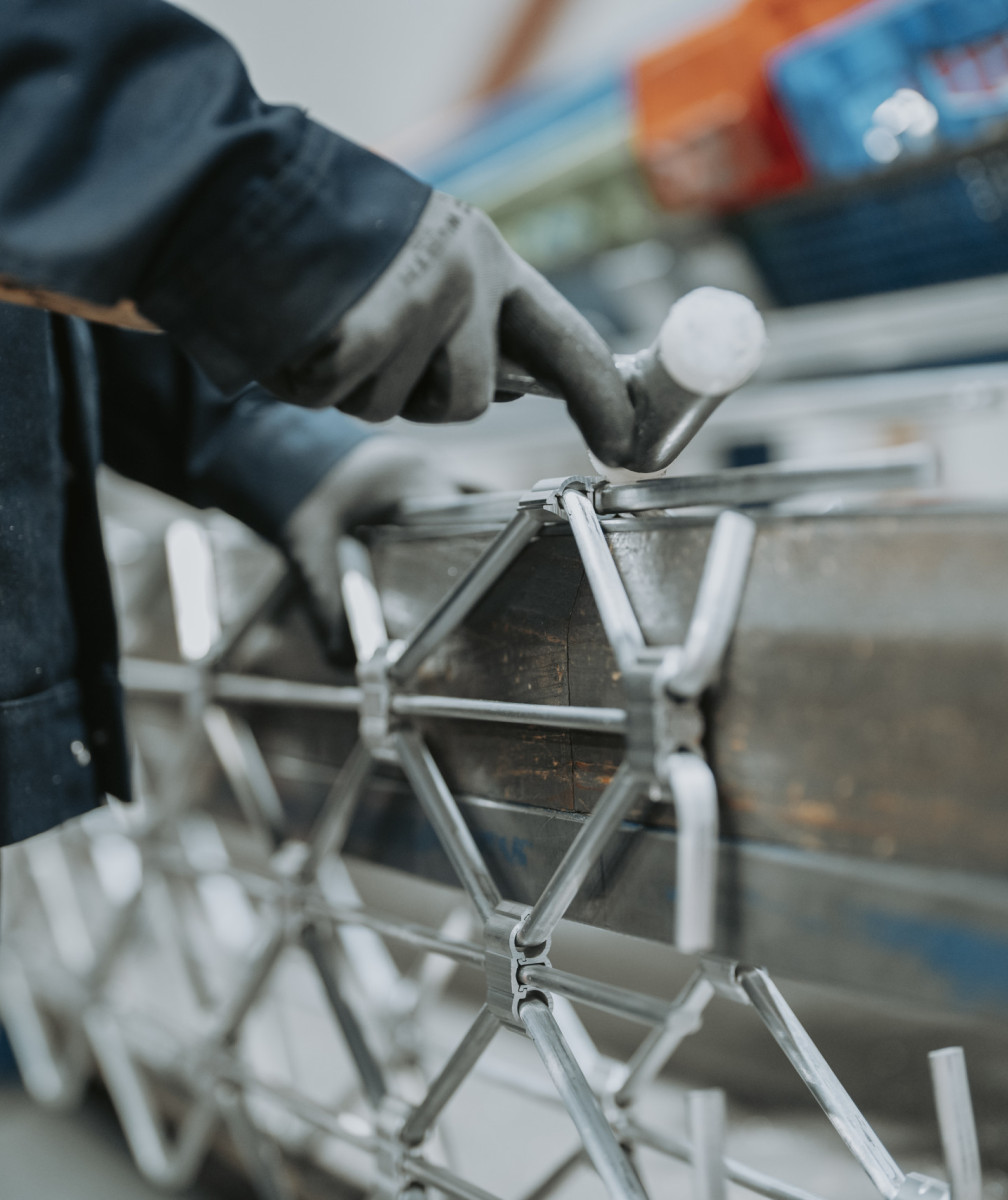 Person bearbeitet ein Metallstück